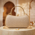 Sac Éclat Champagne présenté sur un socle crème dans un décor oriental