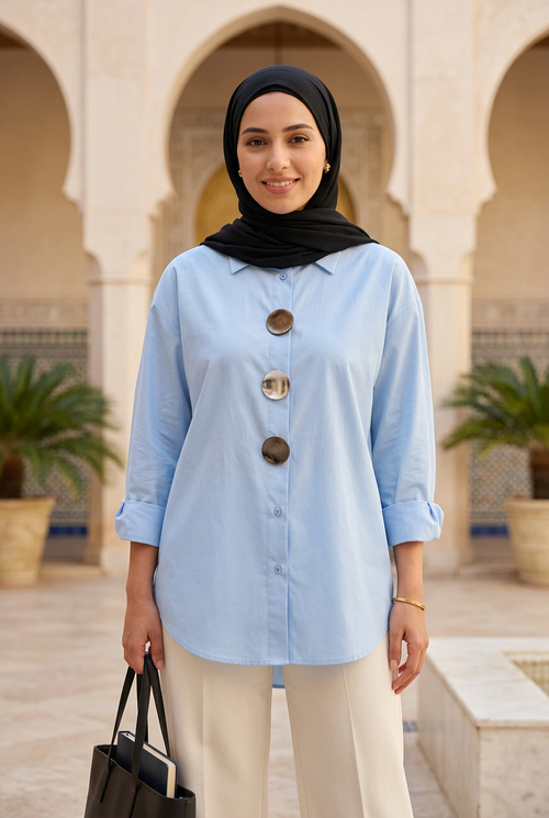 Jeune étudiante portant un foulard noir et le chemisier bleu ciel dans une cour orientale